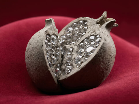Stone pomegranate sculpture with diamond seeds on red