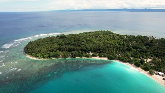 Aerial view of Mushu Island featuring dense tropical vegetation, white sandy beaches, and vibrant turquoise waters over coral reefs in Wewak District, East Sepik Province, Papua New Guinea.