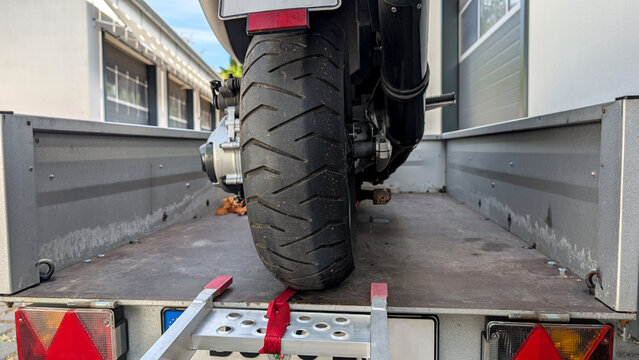 Motorcycle loaded on trailer with ramp. 