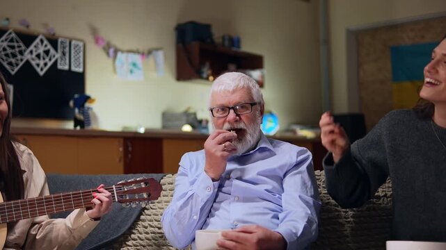An indifferent grandfather surrounded by his cheerful granddaughters