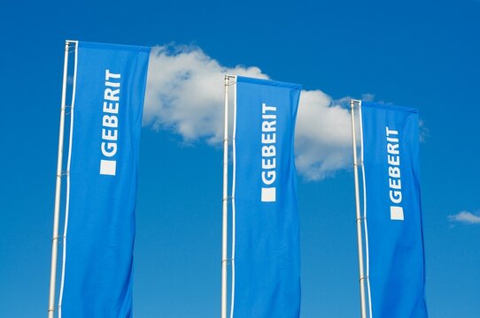 Geberit company flags signs against blue sky in Manno, Switzerland