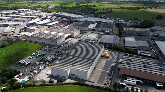 Industrial Estate Aerial View: An expansive aerial perspective showcases a sprawling industrial estate, characterized by large warehouses, logistics centers, and parked vehicles.