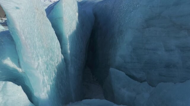 Aerial view of a deep blue glacier crevasse with textured ice walls at Jokulsarlon, Sveitarfelagid Hornafjordur, Iceland.