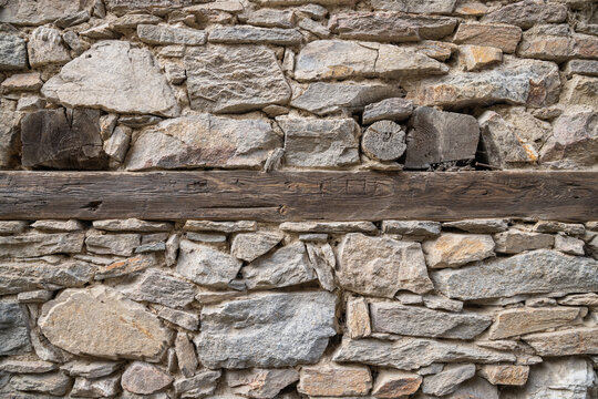 Timber in a rough cut stone wall.