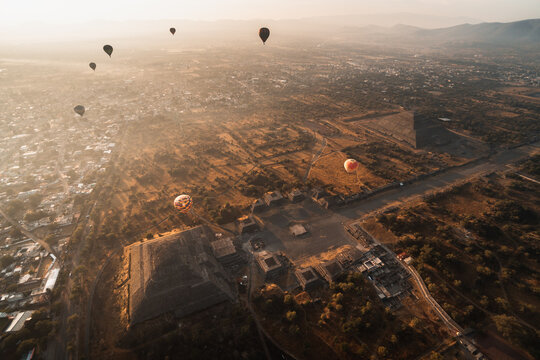 Aerial view of hot air balloons over Teotihuacan pyramids at sunrise in Mexico showcasing ancient architecture and landscape