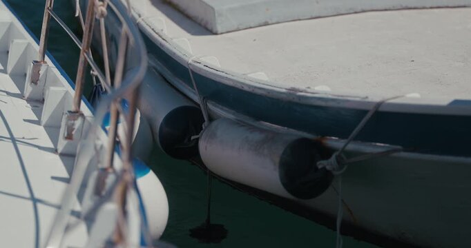 Close up of boat fenders hanging between docked boats in Rovinj, Croatia.