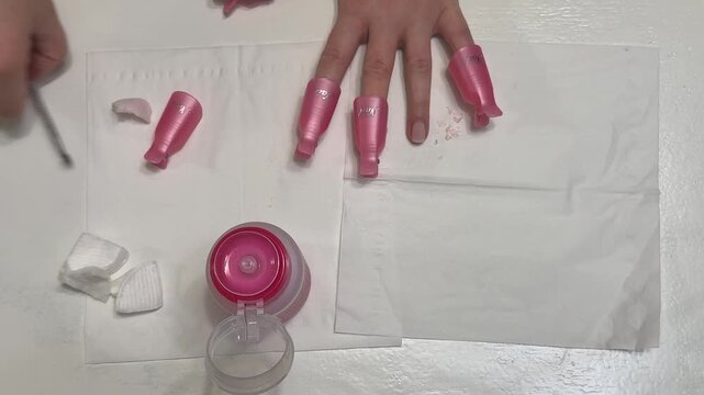 Removing softened gel polish with a metal pusher after using a remover
