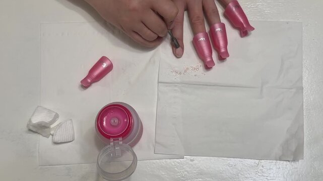 Removing softened gel polish with a metal pusher after using a remover