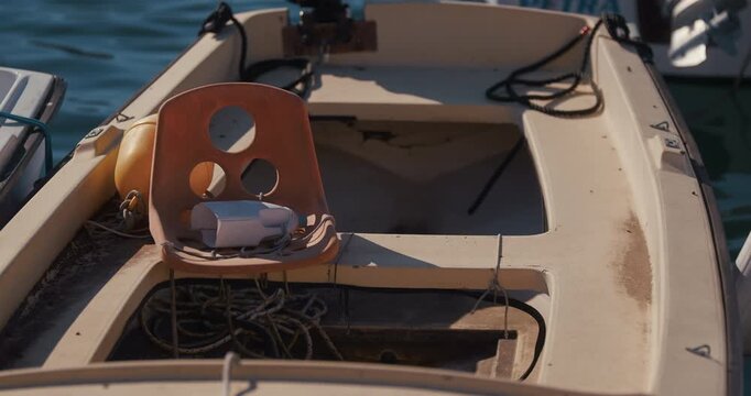 Plastic chair placed inside a small moored boat in a harbor in Rovinj, Istria, Croatia.