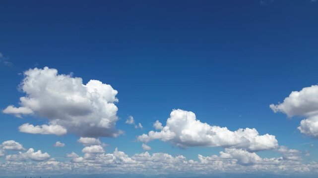 Cloudscape Serenity: A panoramic view of a clear blue sky, adorned with fluffy white clouds, evoking a sense of calm and boundless freedom.