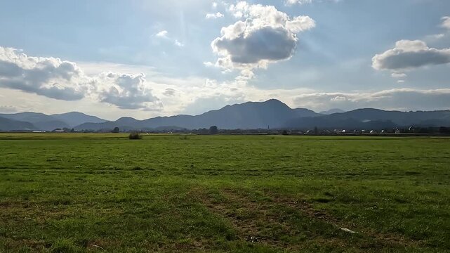 scenic view of farm mountains rural scenery in slovenian countryside (slovenia, europe, julian alps mountains) riding driving biking along road fields of grain tiny town village