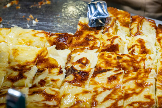 Eating plaza inside the restaurant  Fresh cheese pie lies on the table. Omelet of potatoes cooking in a pan. Omelet of potatoes cooking in a pan. Turkish style meat stuffed filo dough borek served kol