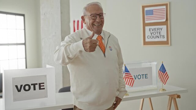 Elderly man gives thumbsup beside a ballot box in a voting building, wearing an orange tie and an i voted sticker while smiling and pointing; civic pride duty.