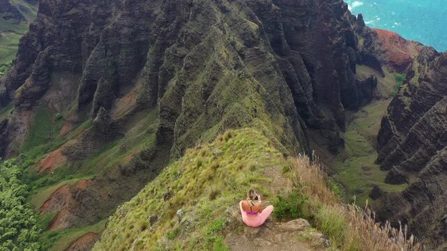 Breathtaking Na Pali Coast landscape with woman on cliff