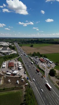 Highway's Rhythm: A captivating aerial view captures a busy highway, bustling with cars and trucks navigating the open road under a vibrant blue sky, highlighting the constant motion of transport.