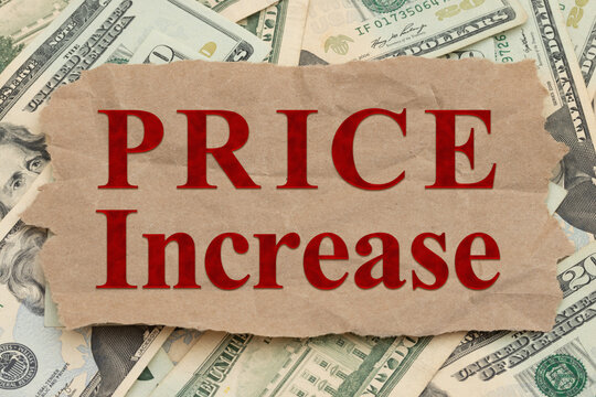 Price increase message on torn paper over money