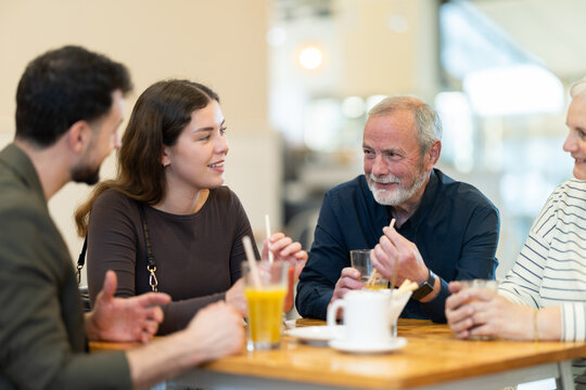 Multi-age group of relatives in restaurant. Organization of meetings, coffee breaks, and festive dinners, family gatherings. Relatives chatting, joking, speaking, have nice conversation, enjoy meeting