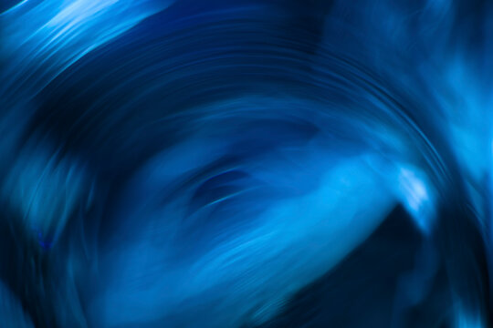 Abstract fluid blue light streaks with swirling motion and dynamic energy