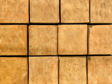 A pattern of stacked terracotta pots that create a textured design with natural earth tones
