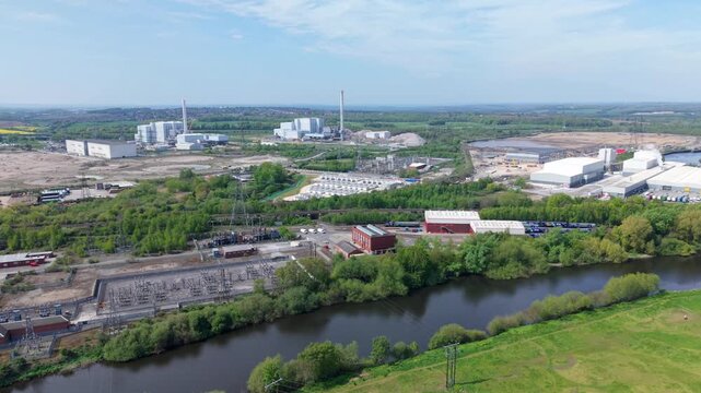Aerial view of National Grid Ferrybridge A Substation and industrial infrastructure near the River Aire with green fields in Knottingley, England, United Kingdom.