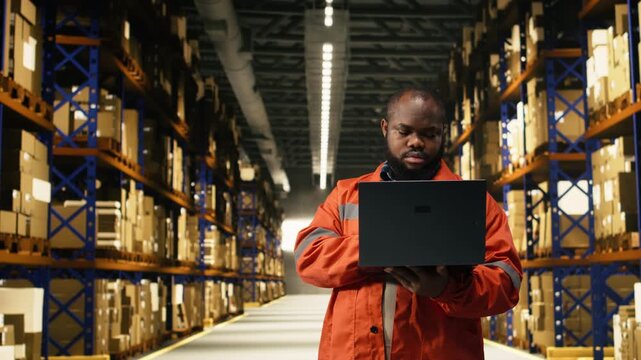 Portrait of black personnel overseeing cargo in large business warehouse. Distribution hub staff coordinates order fulfillment, shipping delivery and handling merchandise for productivity.
