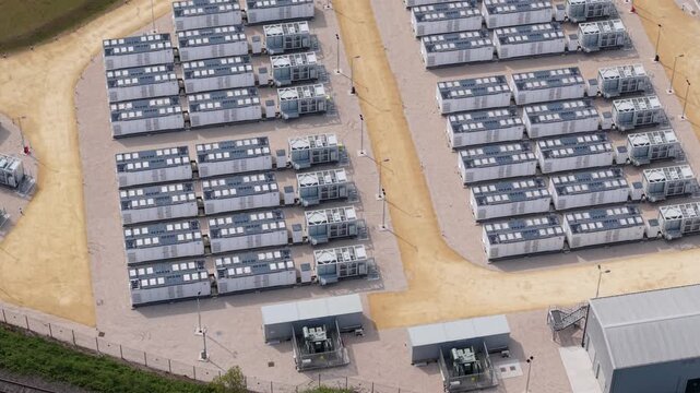 Aerial view of Ferrybridge Battery Energy Storage Systems with rows of white storage units on a gravel site in Knottingley, England, United Kingdom.
