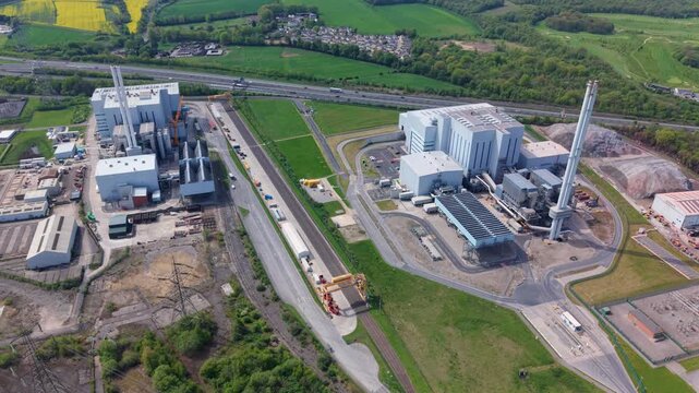 Aerial view of Enfinium 1 and 2 Ferrybridge waste-to-energy facility with tall chimneys and industrial structures surrounded by green fields in Knottingley, England, United Kingdom.