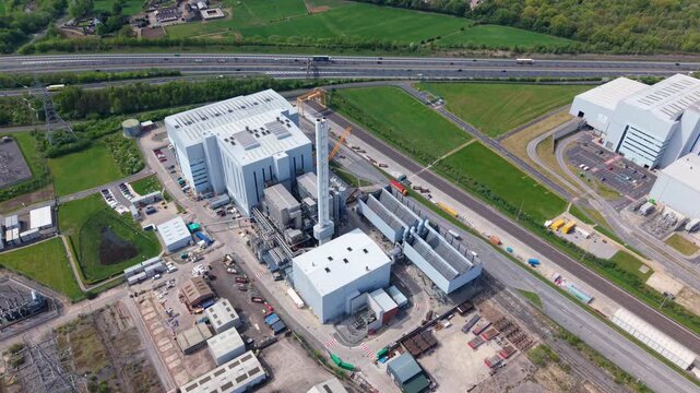 Aerial view of Enfinium 1 and 2 Ferrybridge waste-to-energy plant with its tall chimney and industrial buildings near green fields in Knottingley, England, United Kingdom.