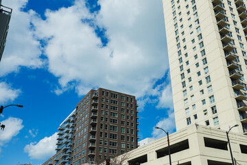 Obraz premium City skyline view with two buildings and blue sky at midday, showing urban life and architecture in a modern setting
