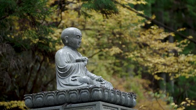 Stone Jizo Bosatsu Statue Wearing Red Bib in a Japanese Temple Garden