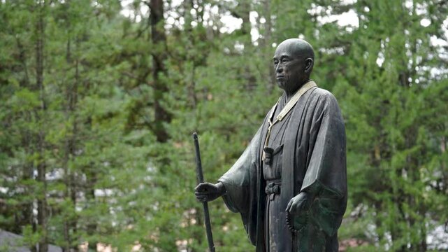 Stone Jizo Bosatsu Statue Wearing Red Bib in a Japanese Temple Garden