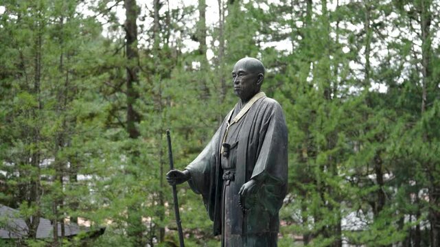 Stone Jizo Bosatsu Statue Wearing Red Bib in a Japanese Temple Garden