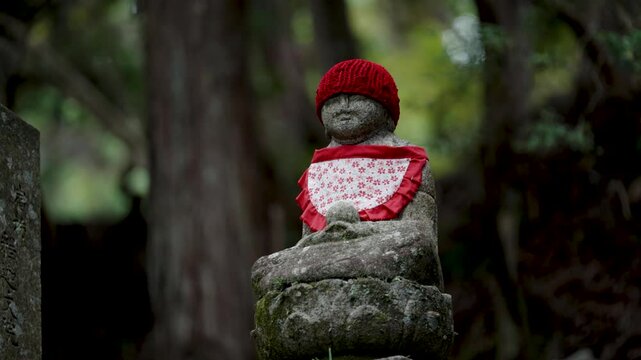 Stone Jizo Bosatsu Statue Wearing Red Bib in a Japanese Temple Garden