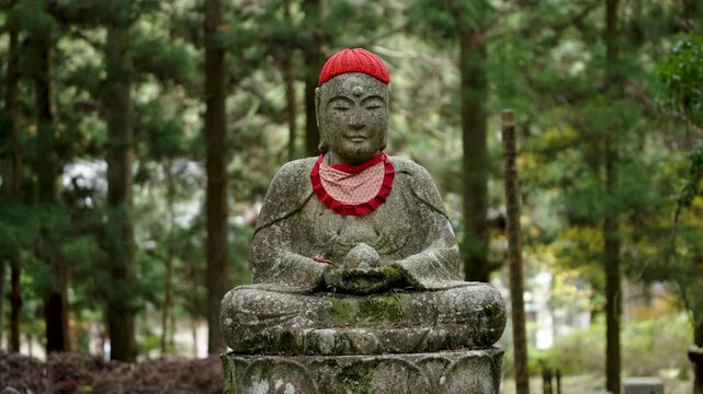 Stone Jizo Bosatsu Statue Wearing Red Bib in a Japanese Temple Garden
