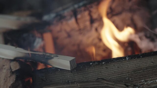 Burning Firewood with Flames and Smoke in Outdoor Setting