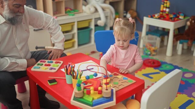 Man placing wooden puzzle pieces and bead maze on red table in playroom building while girl toddler focuses on shapes and markers; calm learning play.