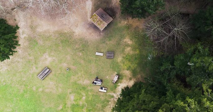 Aerial view of wooden picnic tables and benches on a grassy clearing with people Vallombrosa, Tuscany, Italy.