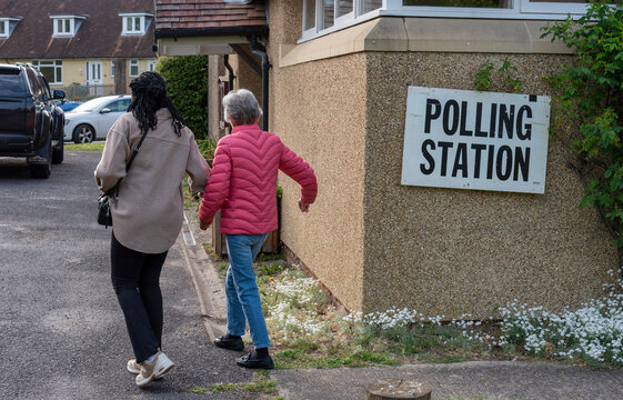 Sutton Scotney Hampshire England UK. 07.05.2026. Women going to vote at a polling station in a small community village hall on election day. Carer and client.