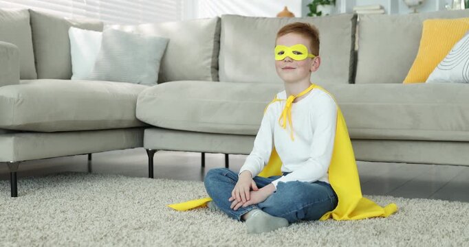 Little boy in superhero costume at home