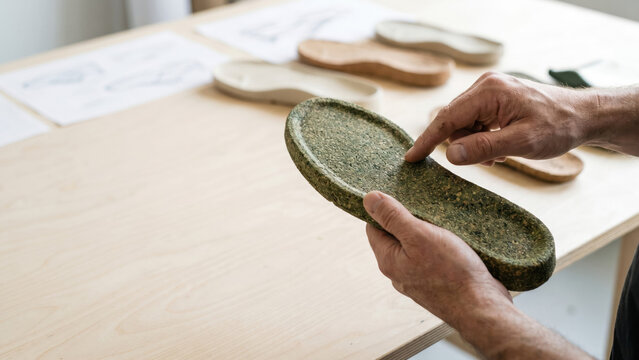 Hands Inspecting Biodegradable Sneaker Sole Made From Recycled Cork and Algae Materials