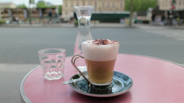 Cafe creme coffee on a pink bistro table at a Parisian sidewalk cafe