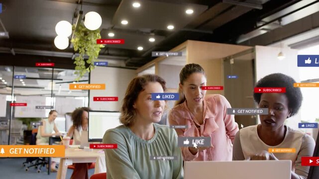 Marketing team reviewing content at laptop in office, tapping trackpad causing floating likes