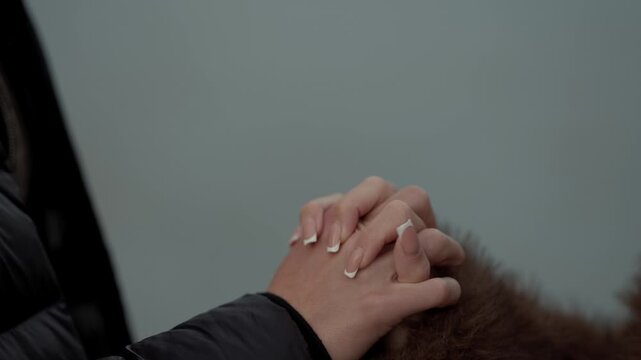 Close-up shot of a couple holding hands in Paris France The video captures a romantic moment of love and connection between two people showcasing an intimate gesture of affection and support Handheld 