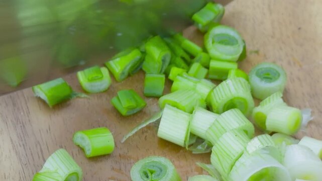 Cooking. Cutting spring onions with black gloves