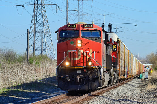 Canadian National Railway locomotives lead a freight train southbound through an area in southwest suburban Chicago dominated by power lines and towers.