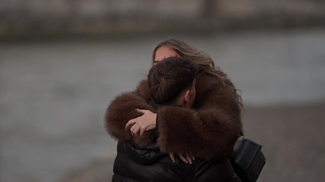 A woman runs in slow motion to embrace a man in Paris France The romantic couple is reuniting The scene captures a happy moment between lovers showcasing a travel lifestyle and love concept They are w