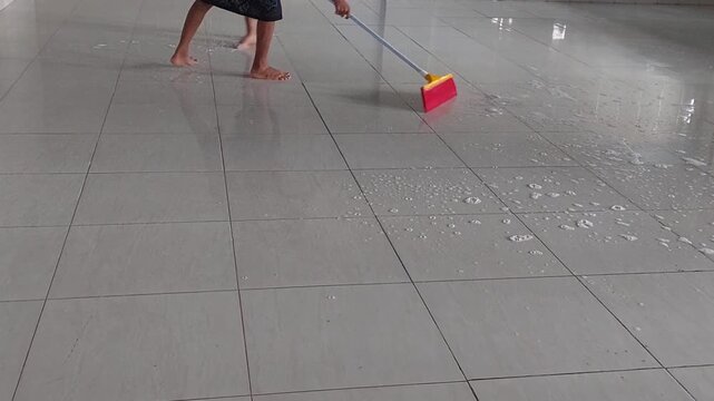 Child Mopping Floor at Home While Helping with Household Chores