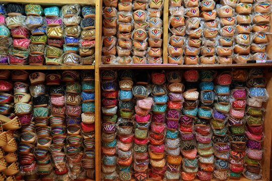 View of traditional colorful embroidered shoes neatly arranged on wooden shelves in a local market Dubai, Dubai, United Arab Emirates.