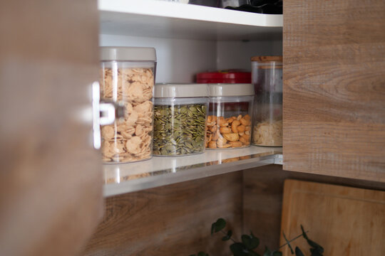 Organized kitchen shelves with containers of food items
