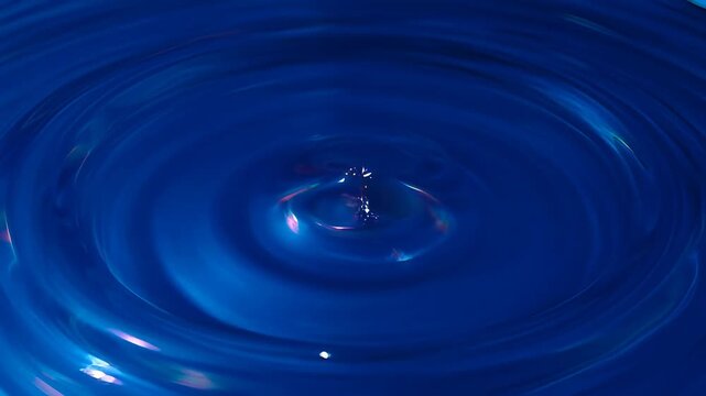 Colourful blue fluid liquid art abstract ripple vortex water surface closeup with glossy swirl texture, luminous concentric ring pattern and smooth circular motion background